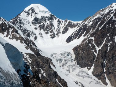Büyük Aktru Buzulu, dağların tepesinde, kar ve buzla kaplı. Altai kış manzarası. Dağlardaki geçide giden karlı yamacın manzarası..