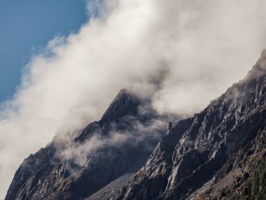 Yumuşak odaklanma. Mistik dağlar. Kalın alçak bulutların üstündeki dağ sırasının tepesindeki atmosferik manzara. Yoğun bulutlar üzerinde dağ sırası olan güzel dağlık bir arazi..