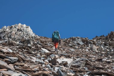Keskin kayalara tırmanıyor. Dağlarda tek başına yürüyüş. Seyahat fotoğrafçısı yaşam tarzı, yürüyüş, bahar tatilinde macera konsepti..