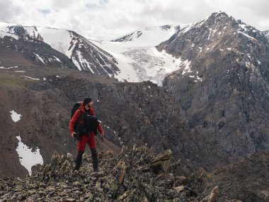 Dağın tepesinde dikilirken etrafına bir bak. Adam bir dağın tepesinde duruyor ve manzaraya bakıyor. Üst dağların muhteşem manzarası. Aktif dinlenme, dağlara yolculuk..