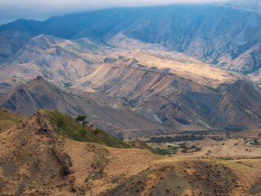Kumlu dağlarda seyahat et. Dağ yapısı, dağ arazisi. Büyük kayalık dağların siluetleri ve destansı derin vadilerle dolu güneşli bir sabah manzarası.. 