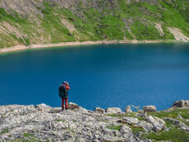 Travel photographer take a picture of the distant mountain turquoise lake from high mountains.Travel freelancer blogger lifestyle, concept adventure voyage outdoor.