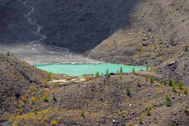 Caldera 'daki Mavi Dağ Gölü. Sönmüş bir volkanın Caldera 'sı bir dağ silsilesiyle çevrilidir. Güneşli sonbahar sarı yüksek irtifa yaylası. 