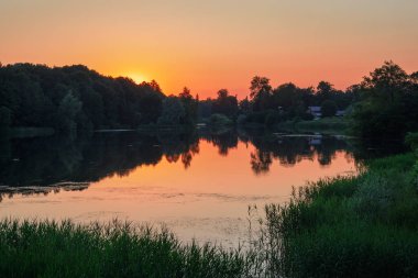 Beautiful sunset on the lake with sunlight. Sunset reflection in a lake.