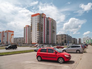Russia. Barnaul. July 2021. Red car in the parking lot of a large modern city.