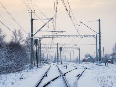 Frosty railway rails, morning arrow, fork, bifurcation of the road. Empty morning railway tracks among the white winter snowdrifts.