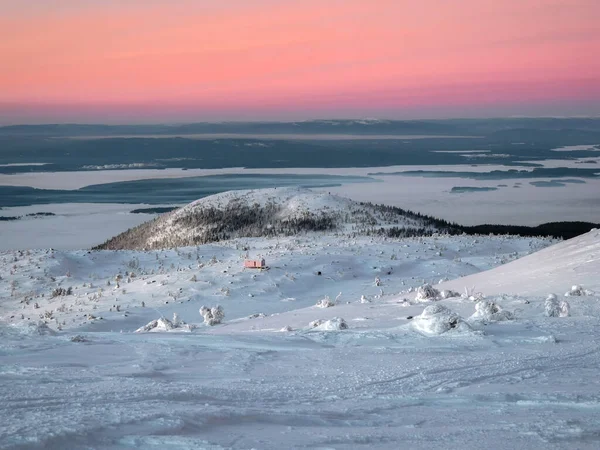 Beautiful Arctic sunset. Scenic colorful sky at dawn. Winter time. Cabin in winter. Dubldom on the mountain Volosyanaya Kandalaksha, Murmansk region in Russia.