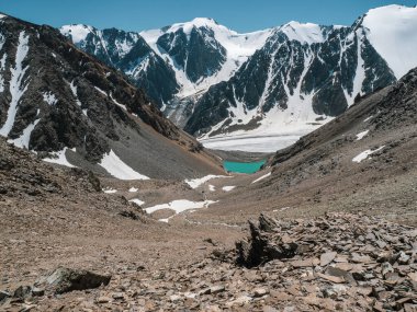 Dağların arkasındaki dağ gölüne güzel bir manzara. Yüksek dağ vadisinde gölü olan atmosferik manzara. 