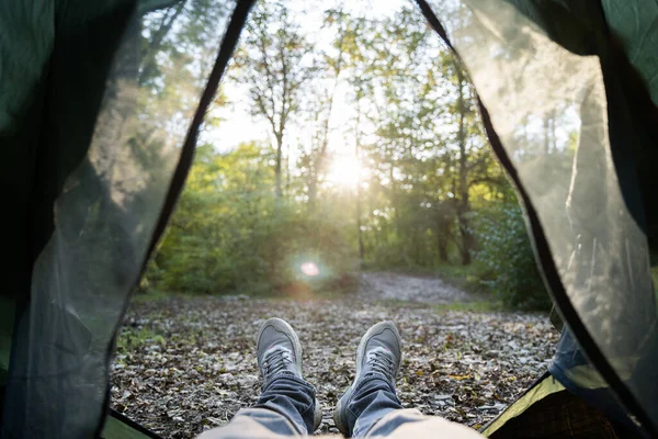 Al campo. Vista in prima persona dalla tenda. Foresta, tramonto, piedi in stivali — Foto Stock