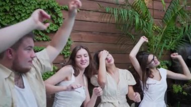 Arkadaşlar yüzme havuzundaki bir partide dans ederler. Açık hava yaz klübünde eğlence.