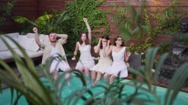 Bir grup arkadaş kutlama ve dans ediyor. Villada yüzme havuzu. Mutluluk ve eğlence birlikte.