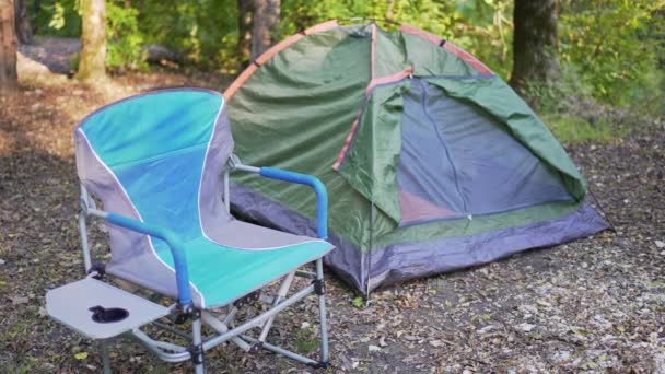 Tenda dan kursi lipat di hutan saat matahari terbenam. Istirahat dan restorasi di alam — Stok Video