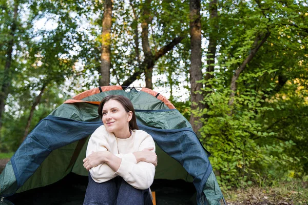 Una bella giovane donna riposa in una tenda nella foresta autunnale. Tranquillità e relax — Foto Stock