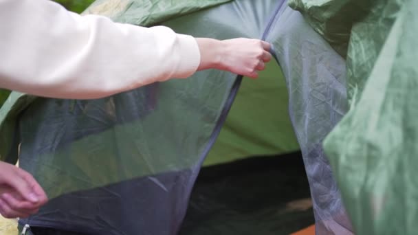 Bir kadın orman kamp alanındaki bir çadırın kopçasını kapatıyor. Yakın plan. Açık hava aktiviteleri — Stok video
