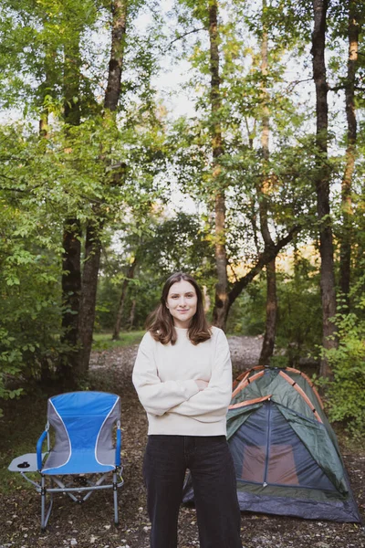 Retrato de uma jovem turista ao lado da tenda. Relaxe na floresta na natureza Imagem De Stock