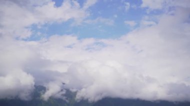 Zaman büyük bulutlarda dağların tepesine çıkar. Bulutlu zirve