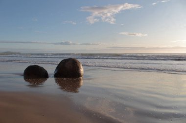 Otago, Yeni Zelanda 'daki Moeraki Sahili' ndeki eşsiz yuvarlak kayalardan ikisi..