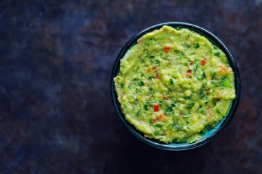 Arka planda bir kase guacamole. Geleneksel Meksika soslu guacamole. Geleneksel Meksika yemekleri. Uzayı kopyala Üst görünüm