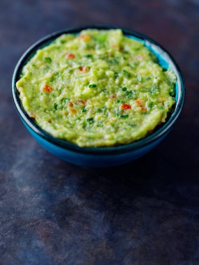 Koyu bir arka planda guacamole. Geleneksel Meksika soslu guacamole kasesi. Geleneksel Meksika yemekleri. Yakın plan.