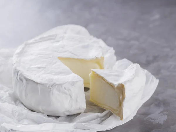 Camembert Szürke Cementes Háttérrel Puha Sajt Fehér Penésszel Pergamenpapíron Másold — Stock Fotó