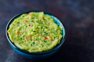 Koyu bir arka planda guacamole. Geleneksel Meksika soslu guacamole kasesi. Geleneksel Meksika yemekleri. Yakın plan.