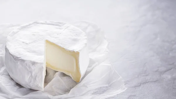 Camembert Szürke Cementes Háttérrel Puha Sajt Fehér Penésszel Pergamenpapíron Másold — Stock Fotó