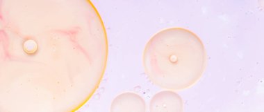 Renkli arka planda suya yağ damlıyor. Soyut pastel baloncuk arka planı. Soyut akışkan kalıp. Kapat.