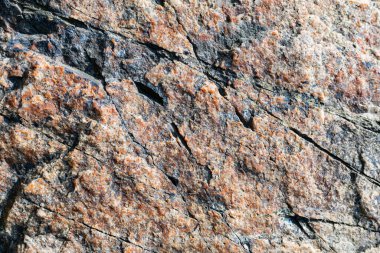 Granit kayanın dokusu. Çatlamış taş yüzeyi havasız kalmış. Granit yüzeyi kapatın. Toprak rengi kavramı