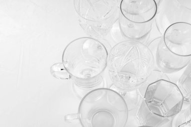 Beyaz arka planda çeşitli boş içki bardakları. Beyaz masadaki boş bardakların arka planı. Uzayı kopyala Üst görünüm