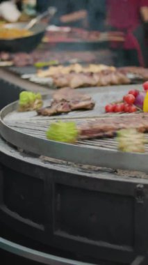 Dönüşümlü barbeküde yemek hazırlıyorum. Kızarmış sebzeler ve domuz pirzolası ile ızgara yapıyoruz. Sokak yemeği. Dikey video