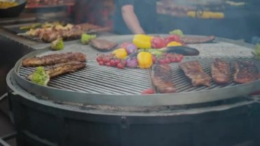 Dönüşümlü barbeküde et ve sebzeler. Kızarmış sebze ve etle ızgara yapıyor. Sokak gıda pazarı