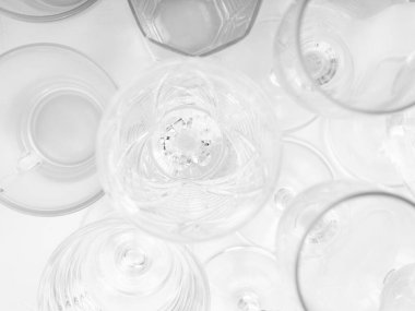 Beyaz arka planda çeşitli boş içki bardakları. Beyaz masada boş bardaklar. Üst görünüm