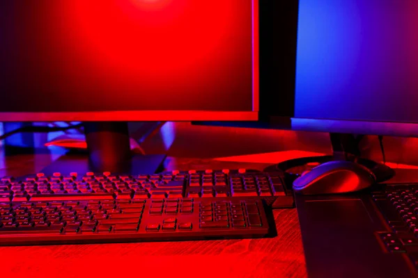 ネオン色の光の中で創造主の職場 視覚的なコンテンツを作成するためのコンピュータ機器 ピンクブルーライトのフリーランサーのホームオフィス ホームオフィスのコンセプト — ストック写真