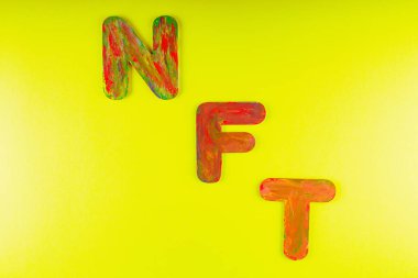 Para iadesi olmayan jeton. Sarı arkaplanda çok renkli harflerin kısaltması. Kripto Sanat konsepti. Uzayı kopyala Üst görünüm