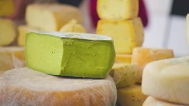 Çeşit çeşit sert peynir. Süt ürünleri büyük parçalar halinde tezgahın üzerinde. Çiftlik peyniri satışları. Süt ürünleri endüstrisi