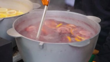 Sıcak şarap hazırlığı. Yeni yıl ve Noel için sıcak şarap. Büyük bir tencerede, karıştırılmış şarap. Yakın plan.