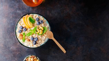 Bir kase yulaf ezmesi, böğürtlen, fındık ve bal. Elma dilimleri ve taze naneli yulaf lapası. Sağlıklı gıda konsepti. Üst Manzara. Boşluğu kopyala