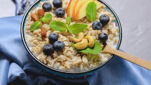 Oatmeal Porridge Berries Nuts Honey Gray Background Oatmeal Blueberries Apple — Stock Video