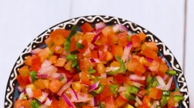 Pico de Gallo soslu kase beyaz arka planda dönüyor. Lezzetli Pico de Gallo salsası ve cips. Meksika yemeği konsepti