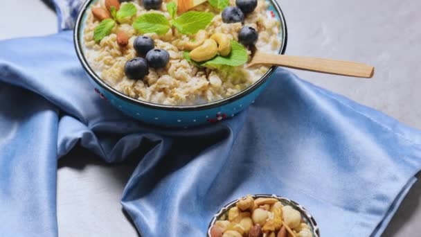 Oatmeal Porridge Berries Nuts Honey Gray Background Oatmeal Blueberries Apple — Stock Video