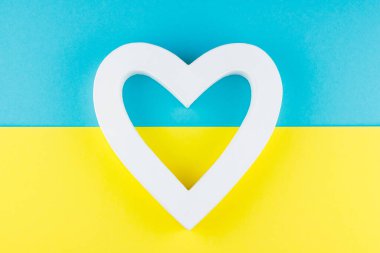 Beyaz kalpli Ukrayna bayrağının ulusal renkleri. Mavi-sarı arka planda beyaz kalp. Ukrayna için vatanseverlik, sevgi ve barış kavramı. Üst görünüm