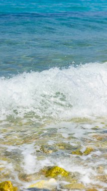 Deniz dalgası ve çakıl taşı. Yaz tatili kavramı. Kıyı şeridinde köpüklü deniz dalgası olayı. Seyahat kavramı