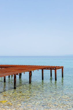 Metal pier and sea view. Rusty skeleton of an old pier and turquoise sea. Unfinished berth in clear water. Sea transport concept