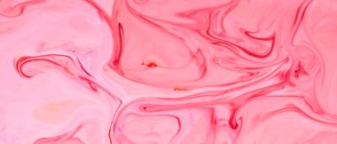 Pembe sıvı soyut yüzey. Su yüzeyinde renkli lekeler. Sıvının üzerinde pembe lekeler olan akışkan sanat dokusu