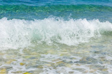 Sahilde beyaz dalgalar. Güneşli bir günde deniz kıyısında. Yaz tatili kavramı