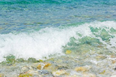 Sahilde beyaz dalgalar. Güneşli bir günde deniz kıyısında. Yaz tatili kavramı