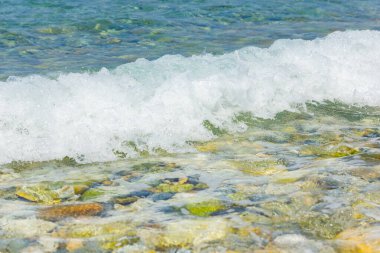 Sahilde beyaz dalgalar. Güneşli bir günde deniz kıyısında. Yaz tatili kavramı