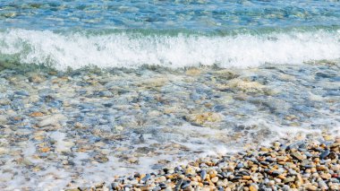 Sahilde beyaz dalgalar. Güneşli bir günde deniz kıyısında. Yaz tatili kavramı