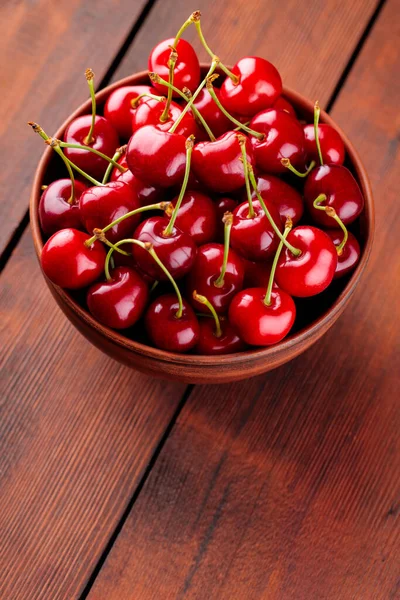 成熟的樱桃在一个粘土碗里 红色的樱桃放在木制桌子上 健康素食的概念 顶部视图 复制空间 — 图库照片
