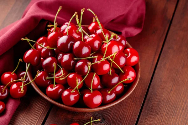 Świeże Czerwone Wiśnie Glinianym Talerzu Czerwonej Serwetce Dojrzałe Wiśnie Drewnianych — Zdjęcie stockowe
